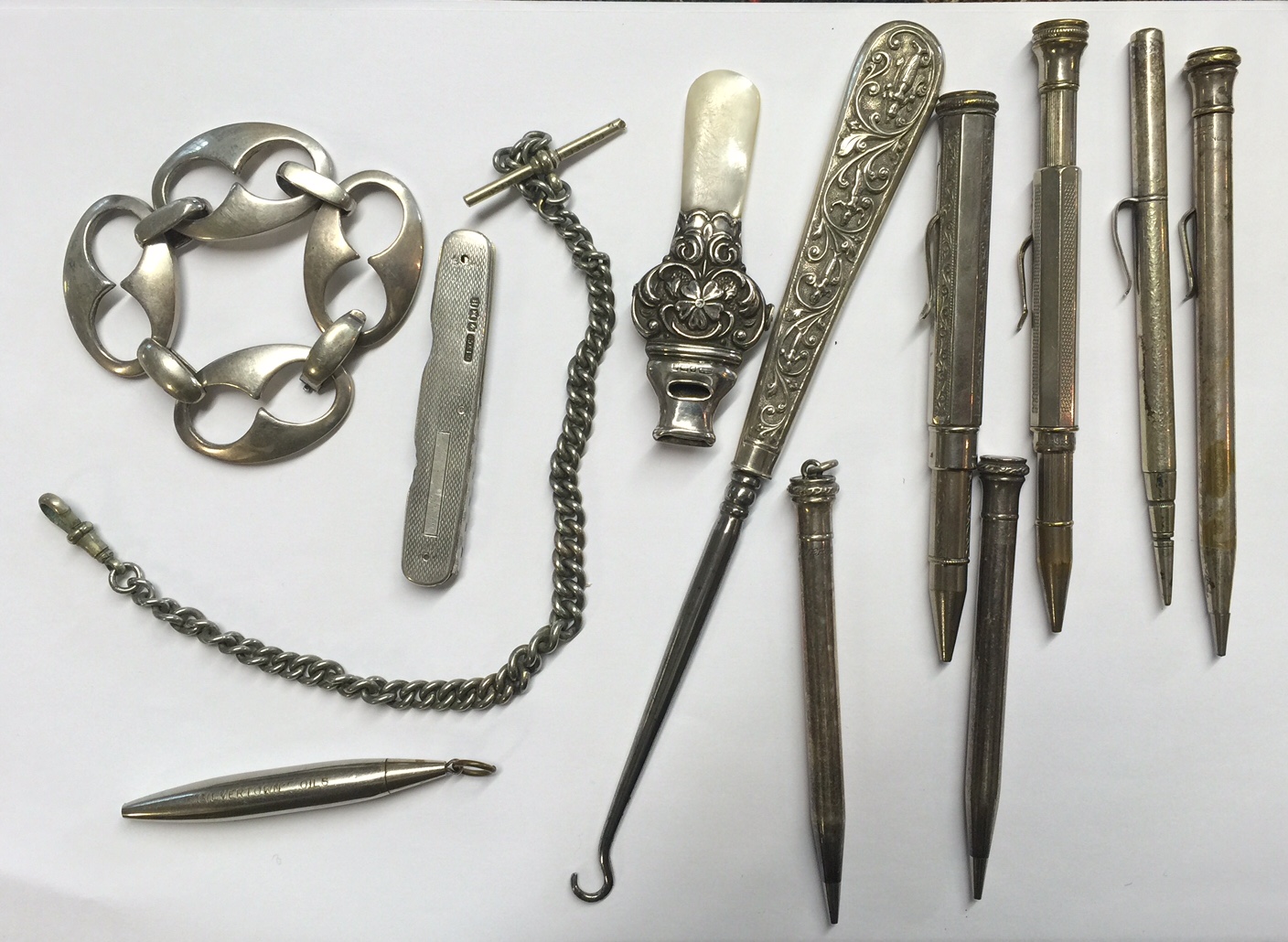 A COLLECTION OF VARIOUS WHITE METAL ITEMS To include babies rattles, Albert chain, propelling