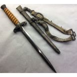 A WORLD WAR II NAZI OFFICERS DRESS DAGGER AND SCABBARD Having an orange amber handle, mounted with