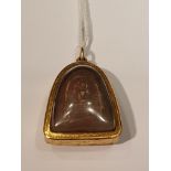 AN 18CT GOLD MOUNTED BUDDHIST PENDANT/AMULET The double sided arch shaped amulet, with an