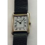 CARTIER, MUST DE CARTIER, A LADIES' GOLD PLATED WRISTWATCH Having a rectangular white dial and black