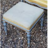 A 19TH CENTURY STOOL With overstuffed upholstered seat, raised on gilt and pale blue turned legs.