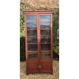 A LATE VICTORIAN MAHOGANY TWO DOOR GLAZED BOOKCASE With a shelved interior, above lower cupboards of
