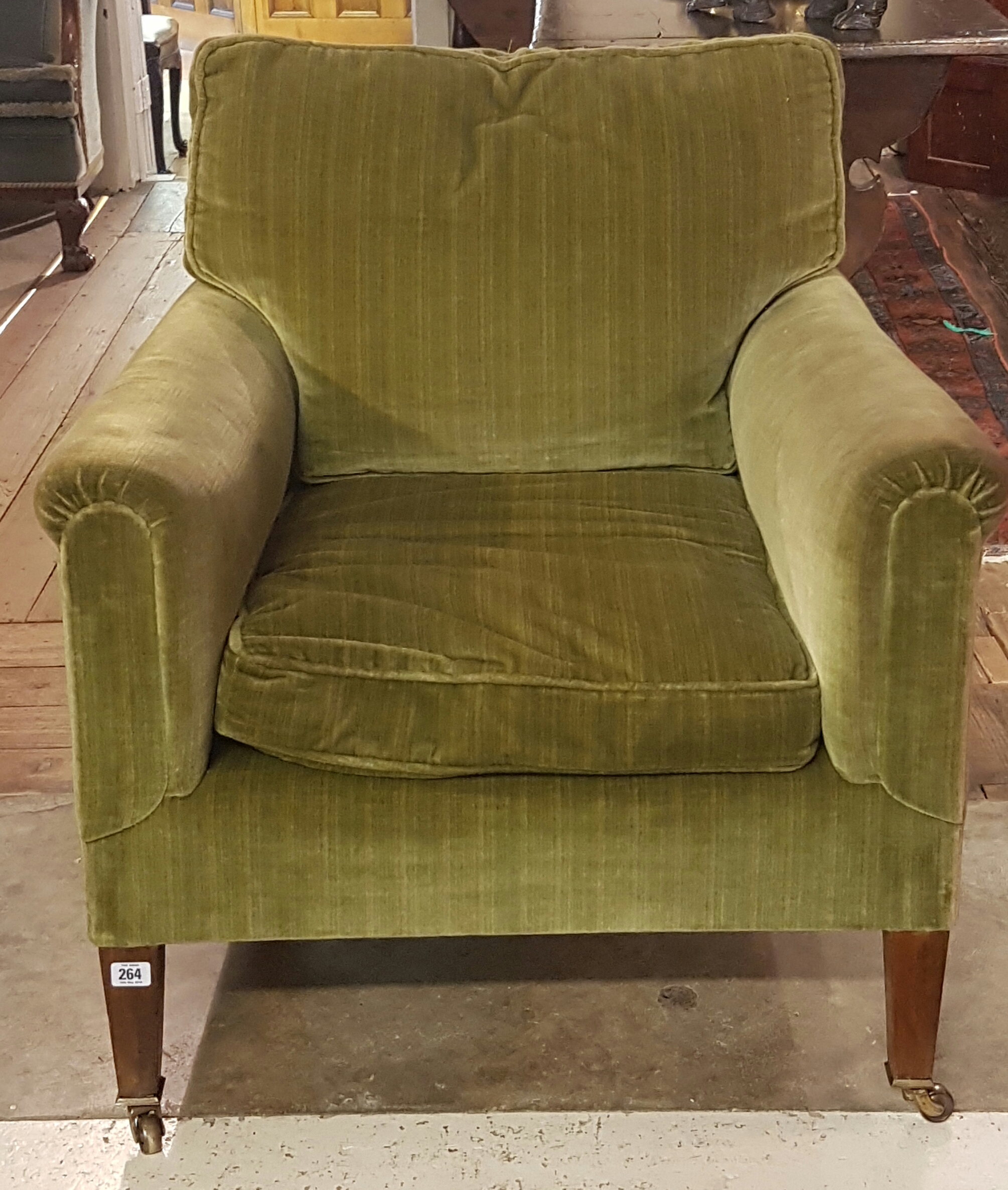A LATE VICTORIAN EASY ARMCHAIR Upholstered in a green velvet, raised on square tapering legs on