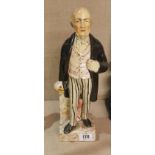 A 19TH CENTURY STAFFORDSHIRE FIGURE OF GLADSTONE Having a long black overcoat, pink waistcoat,