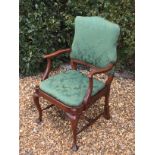 A GEORGE I STYLE MAHOGANY OPEN ARMCHAIR With a shaped upholstered back, above a drop in seat, raised