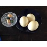 THREE OSTERICH EGGS Resting on a blue glass, scalloped shaped bowl, together with a cut glass tazza,