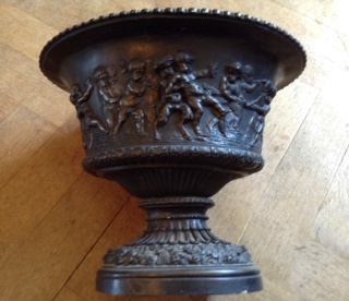 A 20TH CENTURY BRONZED CAMPANA JARDINIÈRE Heavily embossed with classical putti at play, the