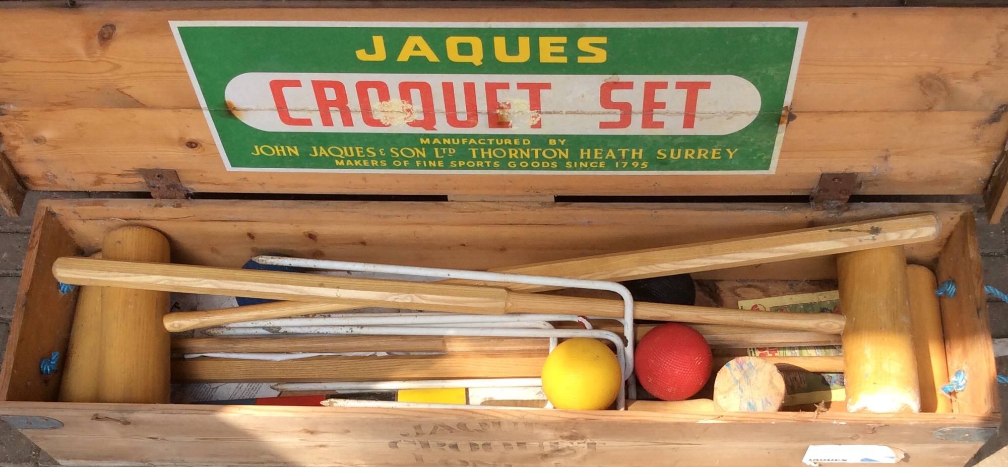 A JACQUES CROQUET SET With four clubs, metal pegs and balls, in original pine Harrod's box. (