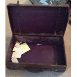 AN EARLY 20TH CENTURY VINTAGE LEATHER SUITCASE Having brass locks and bearing various travel