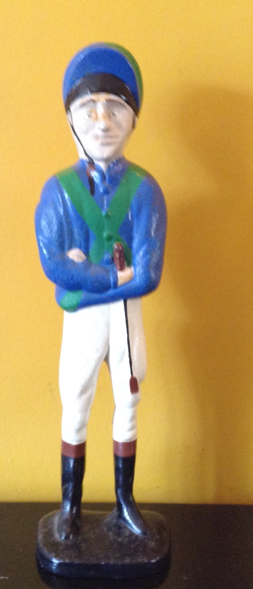 A 20TH CENTURY CAST IRON DOORSTOP Formed as a jockey, wearing blue and green silks and a helmet.
