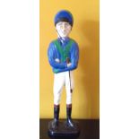 A 20TH CENTURY CAST IRON DOORSTOP Formed as a jockey, wearing blue and green silks and a helmet.