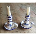 A PAIR OF DELFTWARE BLUE AND WHITE CHAMBERSTICKS Painted with flowers, having a single carry