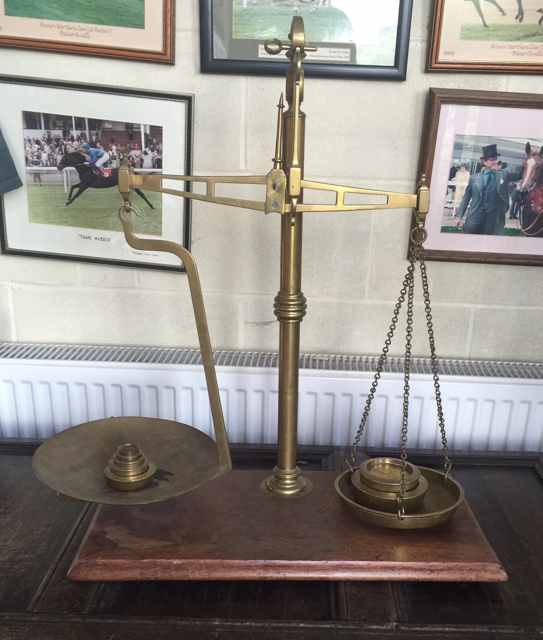 A LARGE SET OF BRASS SCALES AND WEIGHTS On a mahogany base.