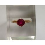 A 9CT ROSE GOLD AND SYNTHETIC RUBY SOLITAIRE RING The circular faceted synthetic ruby claw set, to a