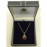 A 9CT GOLD CELTIC DESIGN PENDANT Set with amber oval cabouchon suspended from an 18ct gold rope