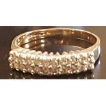 A 9CT GOLD AND DIAMOND RING The two rows of round brilliant cut diamonds, in a white gold setting to