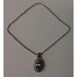 AN 18CT WHITE GOLD AND TOPAZ PENDANT NECKLACE The oval white gold pendant claw set, to centre with a