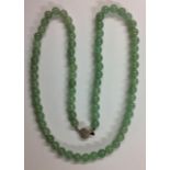 A VINTAGE NECKLACE OF TRANSLUCENT JADE BEADS The seventy-five spherical matched beads, with white