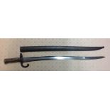 AN ANTIQUE BAYONET With bronze handle, iron scabbard and a gently curved grooved blade, bearing