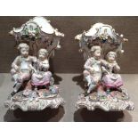 A PAIR OF 19TH CENTURY GERMAN PORCELAIN VASES Each with figures of a seated boy and girl arranging a