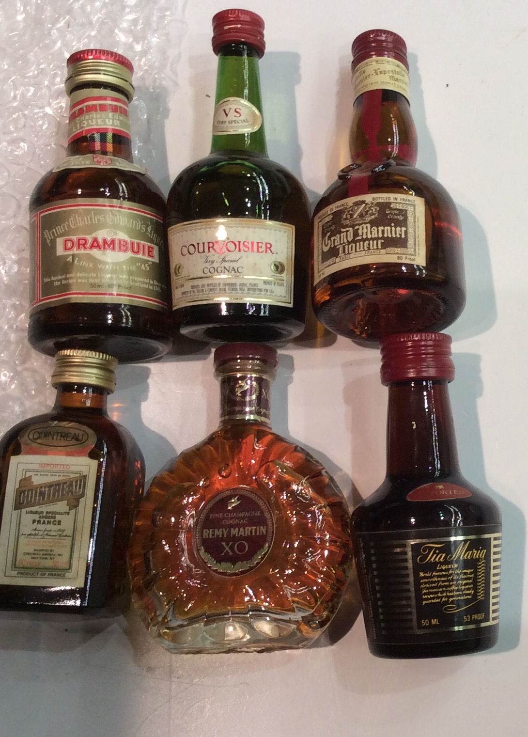 A COLLECTION OF SIX VINTAGE MINIATURE BOTTLES OF COGNAC Drambuie, Courvoisier, Gran Manier,