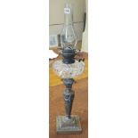 A LATE VICTORIAN OIL LAMP The clear glass reservoir, standing on an Adams design bronze base, with
