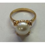 AN 18CT GOLD AND CULTURED PEARL RING The large white cultured pearl, held within four prominent