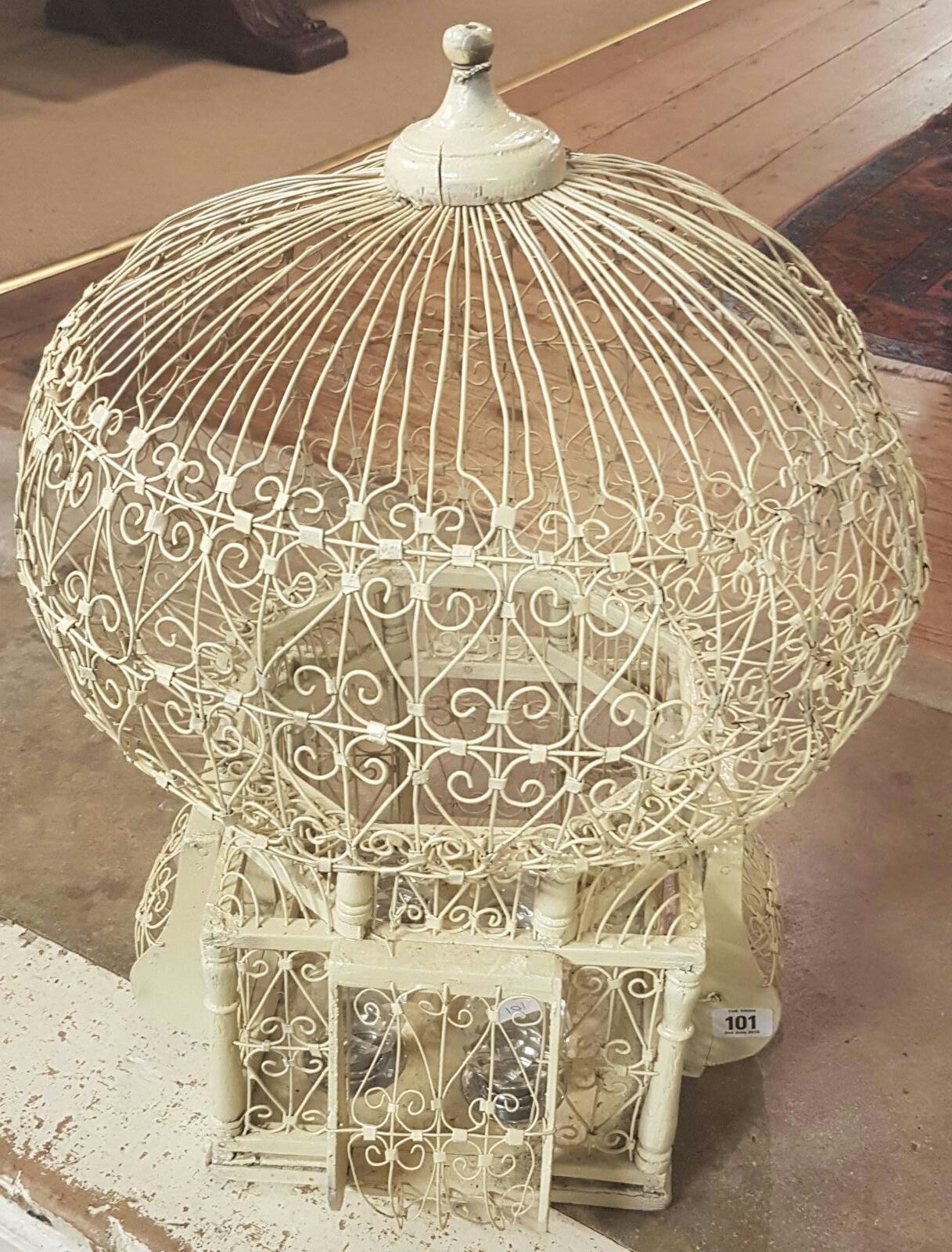 A MID 20TH CENTURY CREAM PAINTED WIREWORK BIRD CAGE Along with a set of four glass door knobs. (54cm