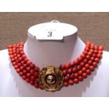 AN ANTIQUE STAINED IVORY FOUR STRAND NECKLACE With gold clasp and brooch.