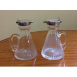 A PAIR OF EARLY 20TH CENTURY GLASS WHISKY/WATER EWERS With silver hinged tops, hallmarked for