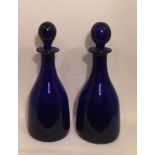 A PAIR OF 19TH CENTURY BRISTOL BLUE DECANTERS AND STOPPERS. (28cm)
