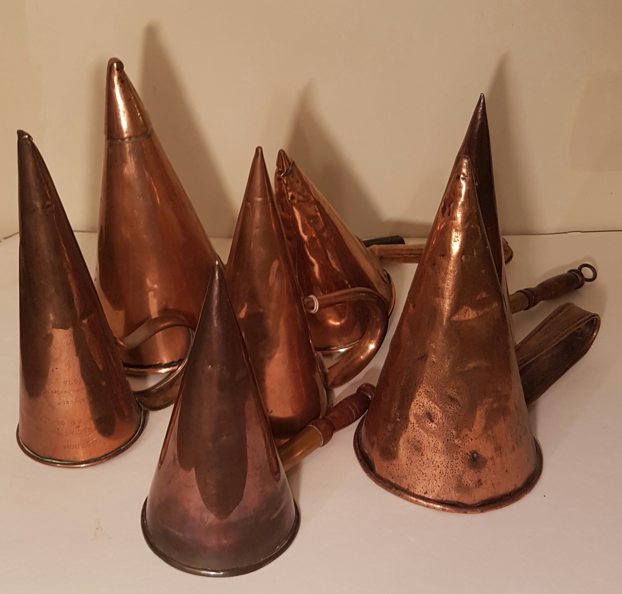 SEVEN 19TH CENTURY COPPER CONICAL ALE/BEER WARMERS. (largest 27cm)