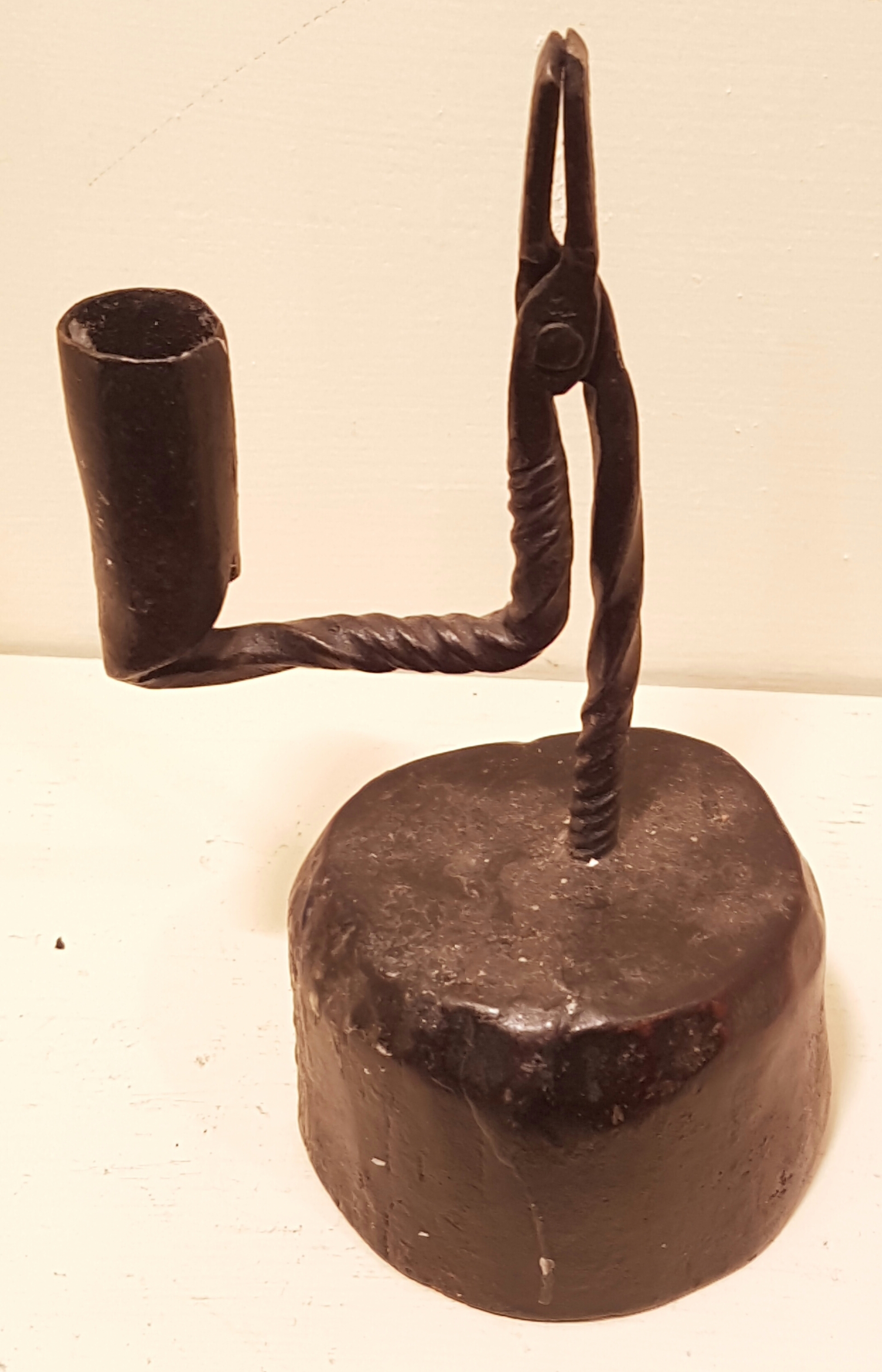 AN 18TH CENTURY IRON TABLE RUSHLIGHT AND CANDLE SOCKET Of spiral stem and bracket arm, raised on a