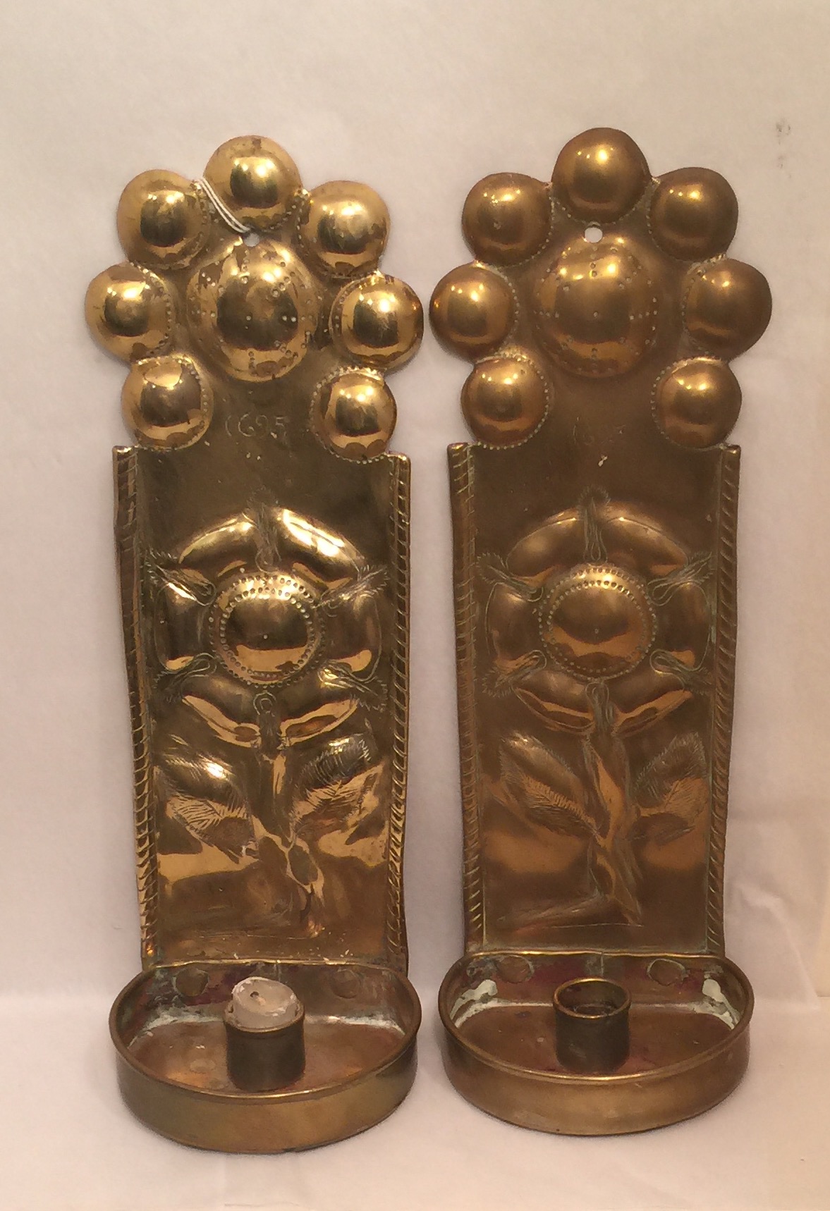 A PAIR OF HEAVY BRASS WALL SCONCES With floral repoussé decoration and dated 1695. (9cm x 30cm x