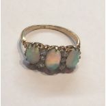 AN EARLY 20TH CENTURY 18CT GOLD, OPAL AND DIAMOND RING Having three graduating cabouchon cut