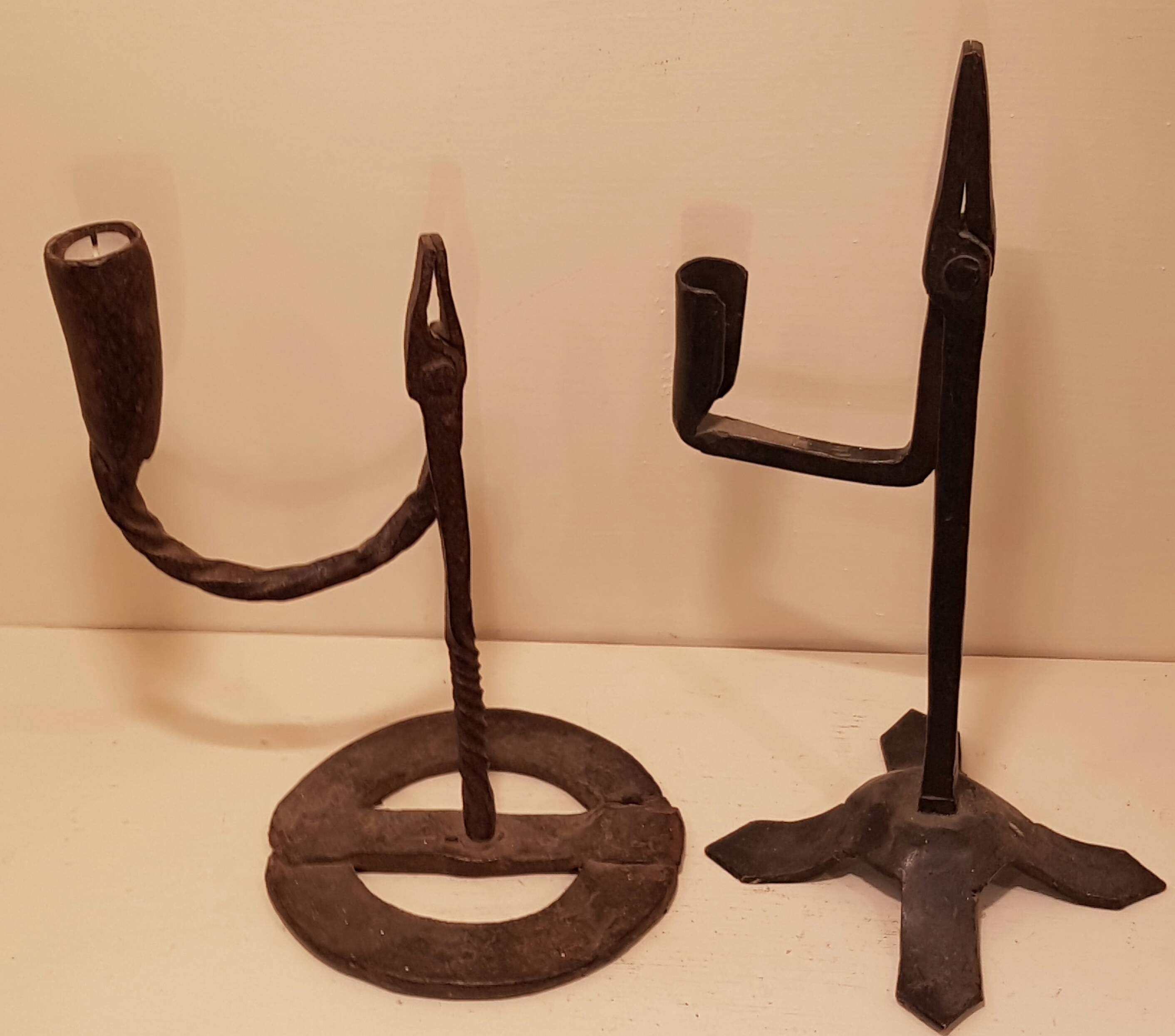 AN 18TH CENTURY IRISH IRON TABLE RUSHLIGHT HOLDER AND CANDLE SOCKET With wide ring base and spiral