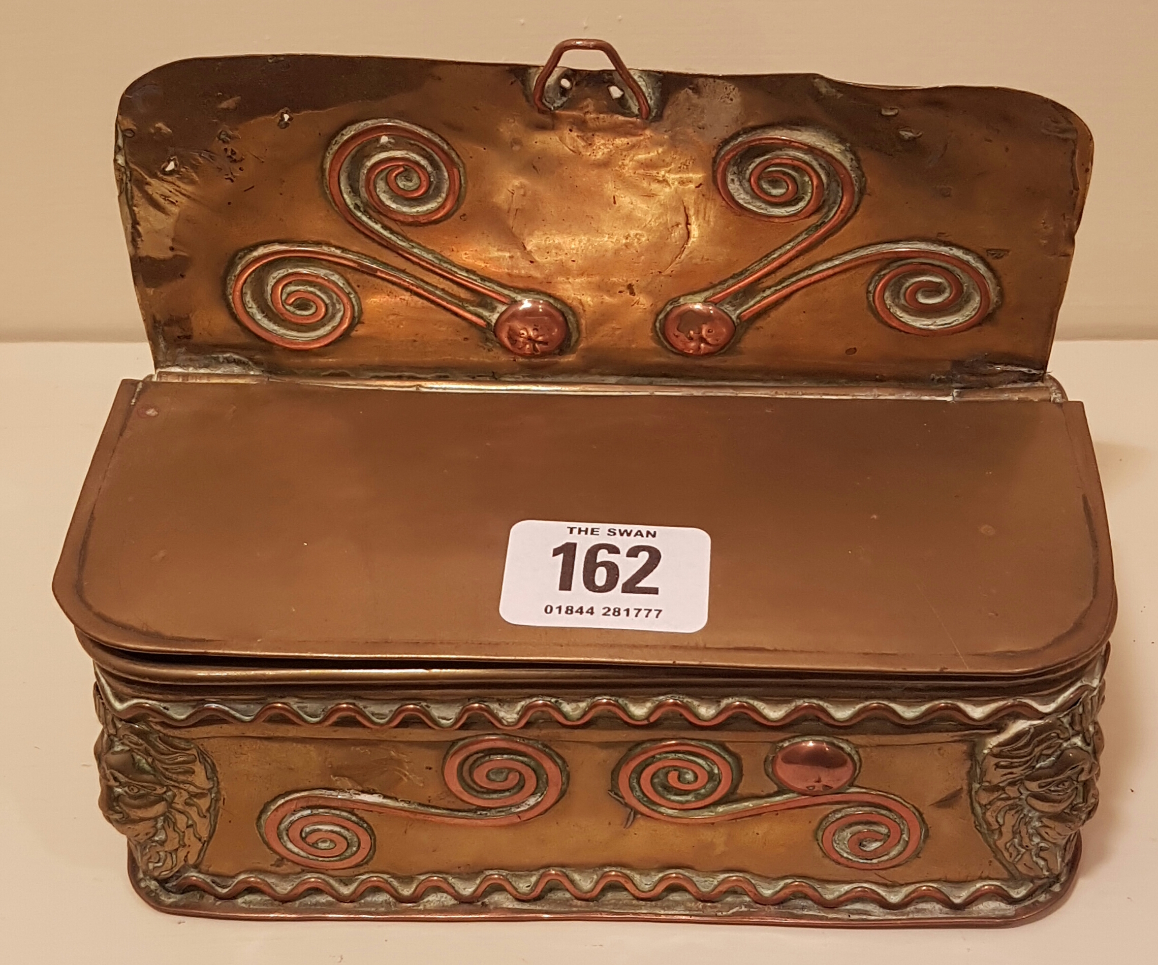 AN 18TH CENTURY SHEET BRASS AND COPPER CANDLE BOX With scroll work decoration, cornered with lion