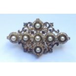 A VICTORIAN 18CT GOLD, PEARL AND DIAMOND CRUCIFORM BROOCH The cross design of seven small pearls (