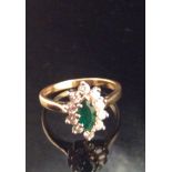 AN 18CT GOLD, EMERALD AND DIAMOND OVAL RING Surrounded by ten round cut diamonds (size N). (approx