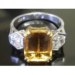 AN 18CT BICOLOUR GOLD, GOLDEN TOPAZ AND DIAMOND THREE STONE RING The rectangular step cut golden