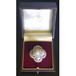 A PLATINUM, PEARL AND DIAMOND SET FUR CLIP/BROOCH The domed, quatrefoil design platinum brooch, with