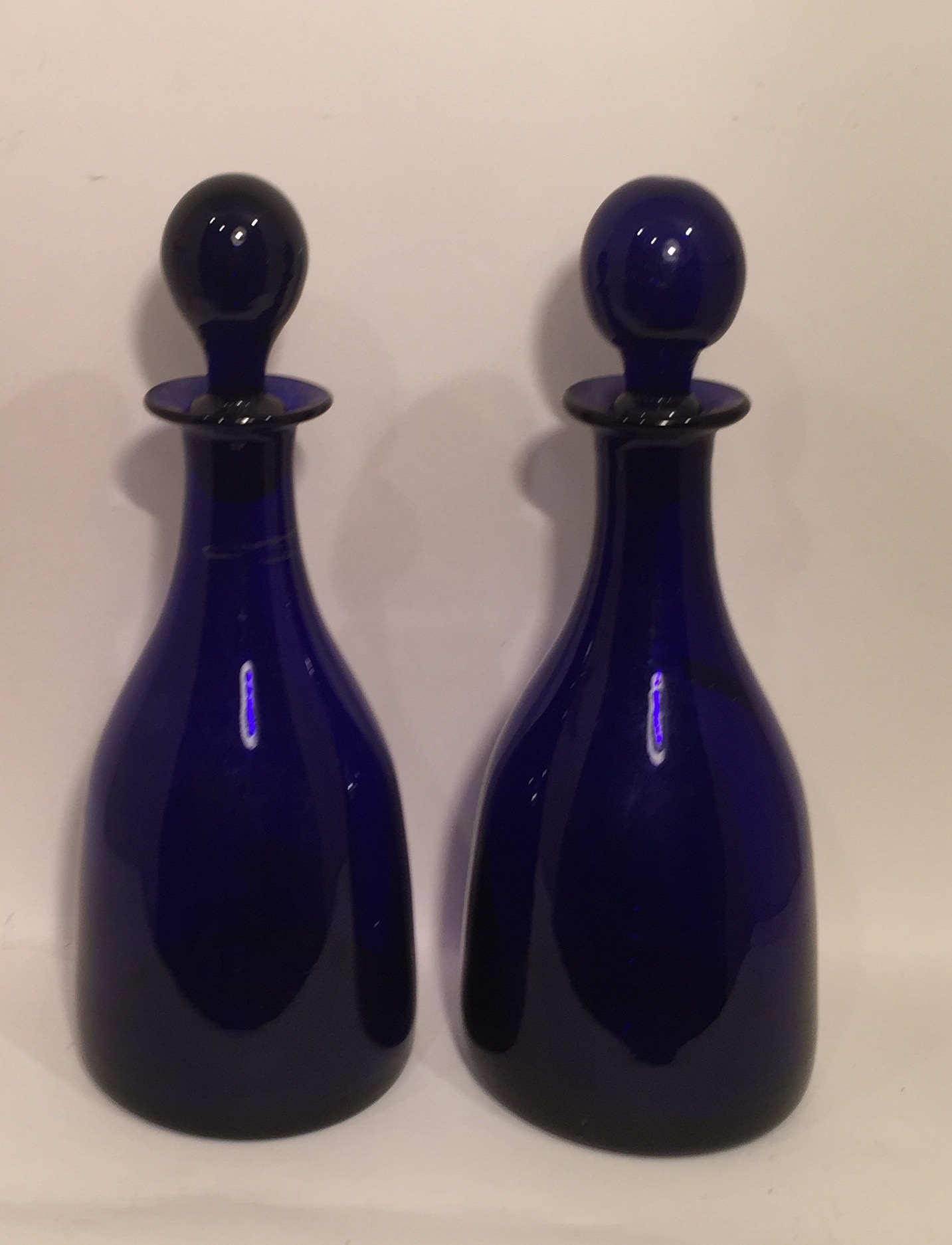 A PAIR OF 19TH CENTURY BRISTOL BLUE DECANTERS AND STOPPERS. (28cm)