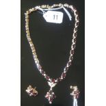 A SUITE OF 18CT GOLD, GARNET AND DIAMOND NECKLACE AND MATCHING EARRINGS The Riviere necklace of claw