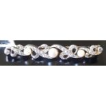 A LATE VICTORIAN/EDWARDIAN DIAMOND AND PEARL BAR BROOCH The three graduated pearls (untested) in a