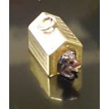 A 9CT GOLD CHARM IN FORM OF A DOG KENNEL The small gold house form kennel, with a small glass dog