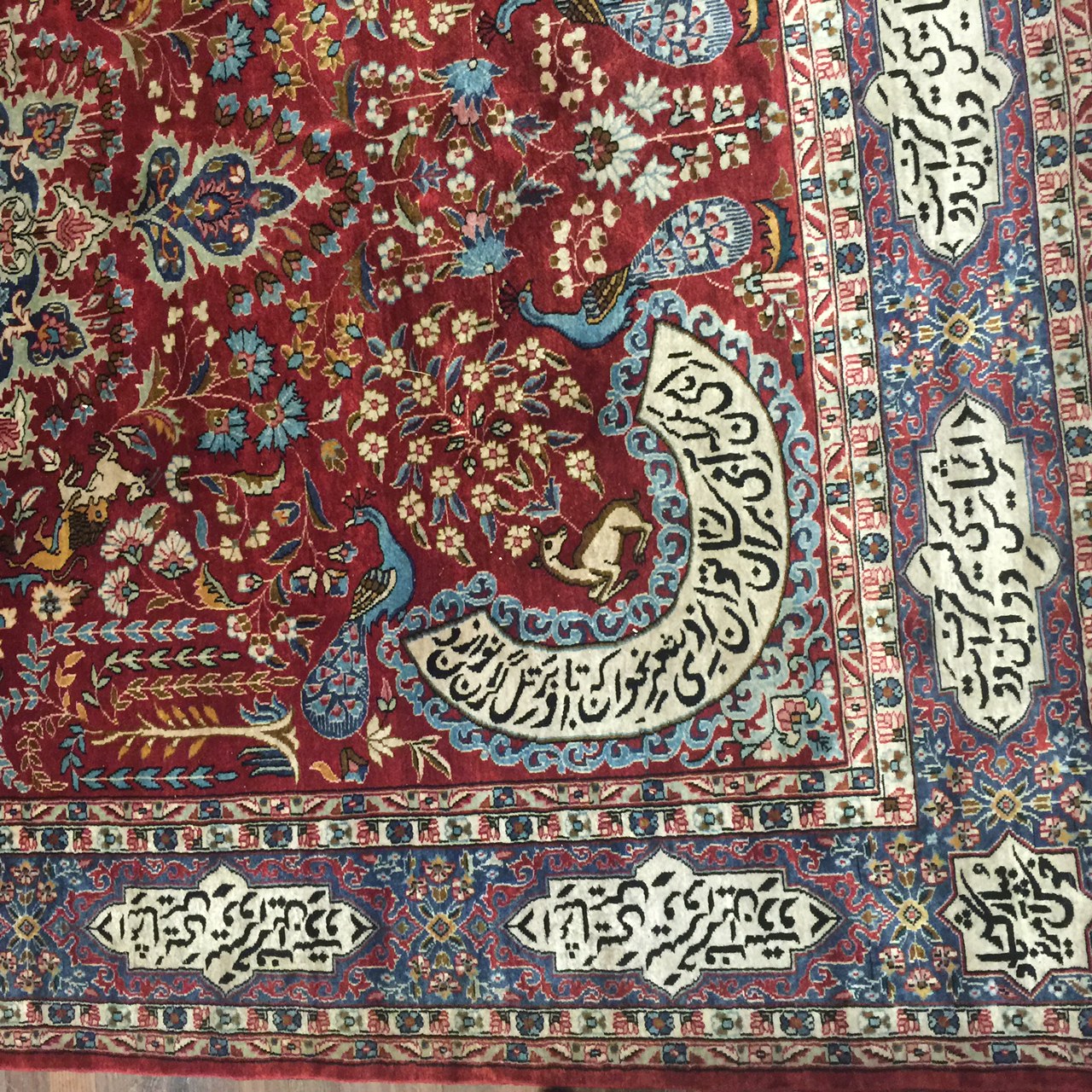 A PERSIAN RUG With central madder field and numerous script, contained within running borders. ( - Image 3 of 5