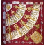 HERMÈS, A VINTAGE SILK SCARF 'Cliquetis', by J. Abadie, russet red ground, with Hermès box. (