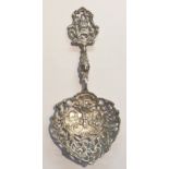 A LARGE CONTINENTAL SILVER SPOON Having an embossed design, of a farming scene, with a pierced