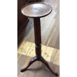 A 19TH CENTURY MAHOGANY TORCHÈRE The circular top on a reeded column, with splayed legs. (101cm)