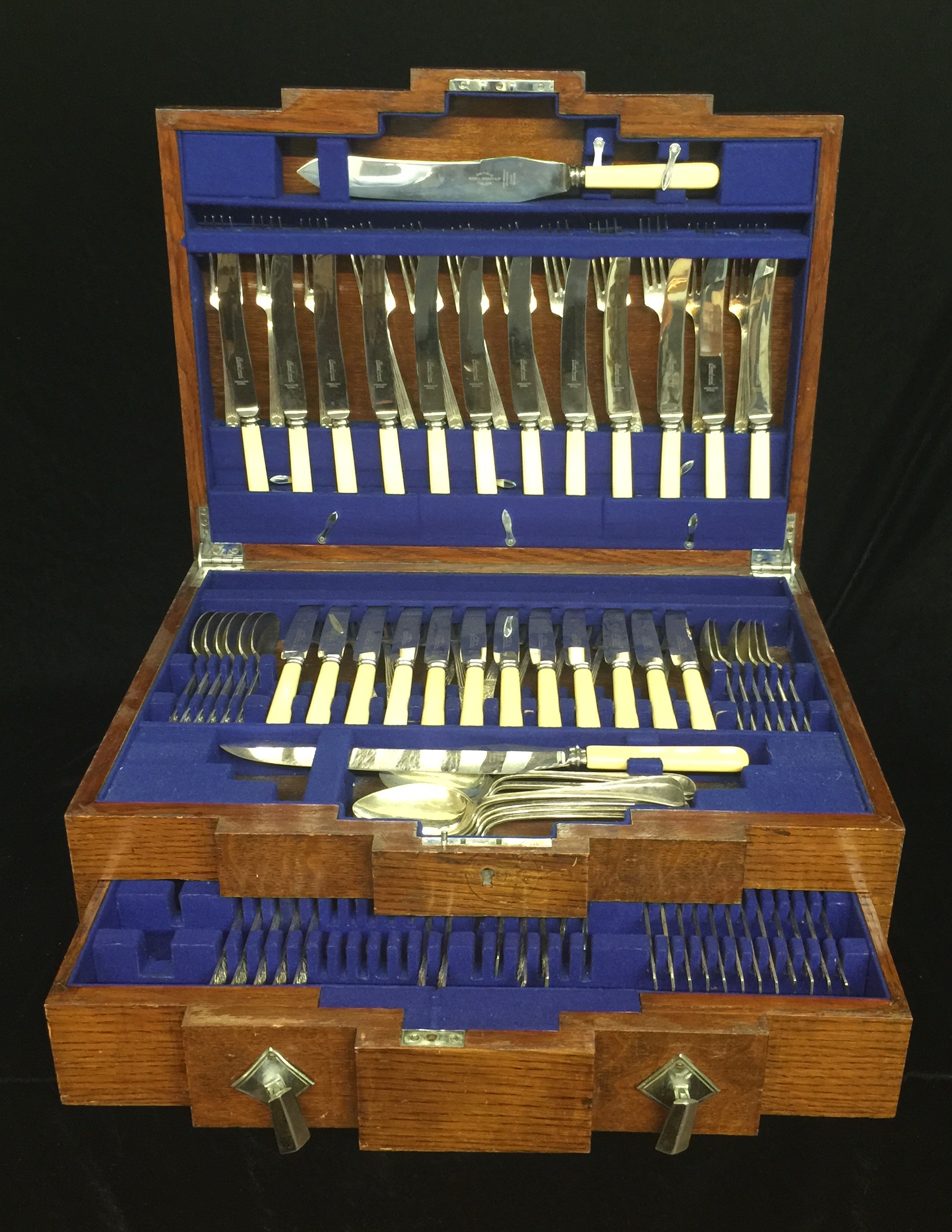 AN EXTENSIVE ART DECO PERIOD OAK CASED CANTEEN OF CUTLERY With silver plated spoons and forks.